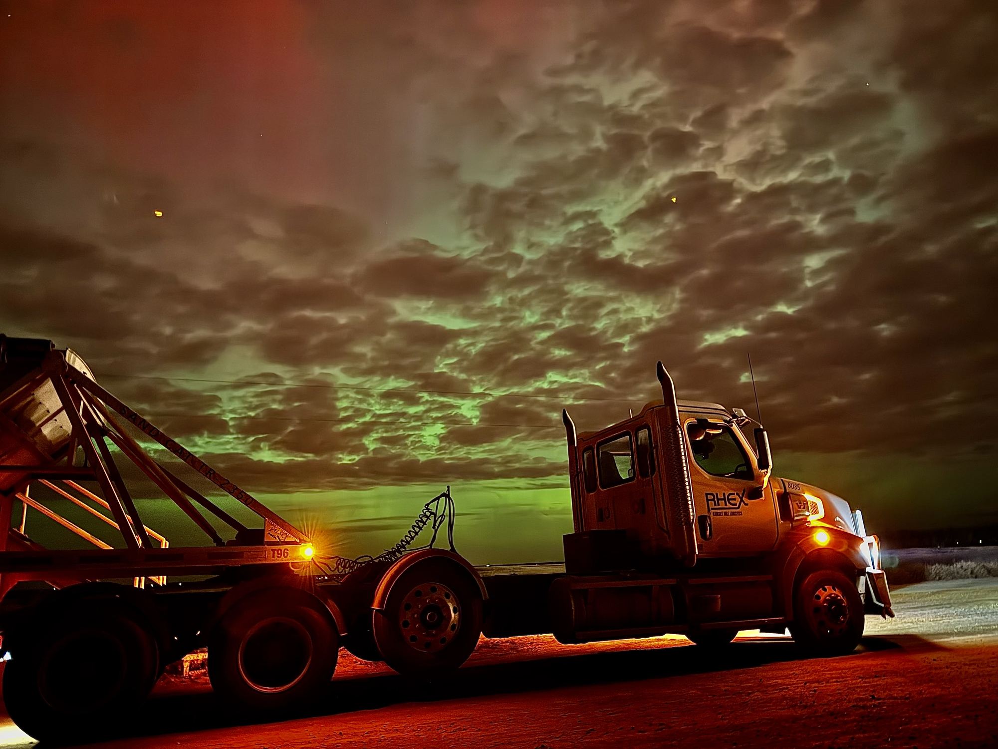 Truck and hopper trailer under the northern lights